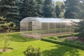 Wydłużona konstrukcja szklarni Botanic Rolnik z poliwęglanu i stali ocynkowanej, w ogrodzie